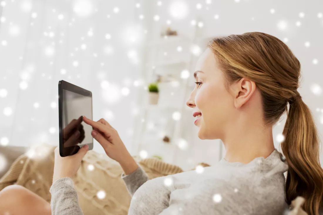 technology-internet-people-concept-smiling-woman-sitting-couch-with-tablet-pc-computer-home-snow