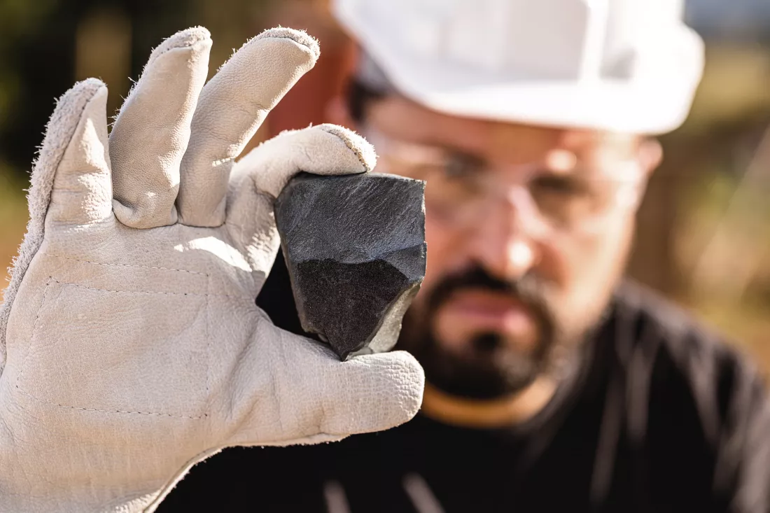 rough-iron-stone-ferrous-metal-nugget-mined-miner-holding-hematitia-stone-spot-focus