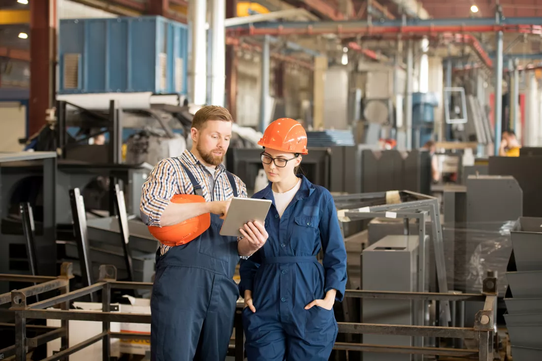 young-confident-technician-overalls-showing-his-colleague-online-data-tablet-explaining-it-meeting-workshop