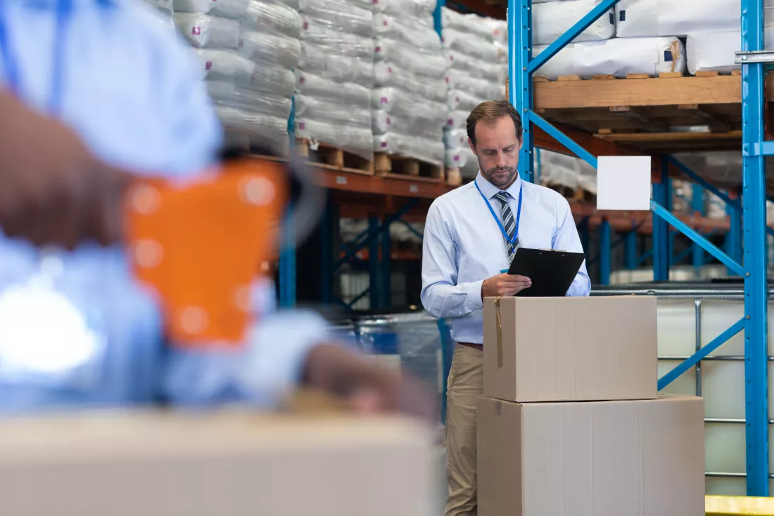 male-supervisor-working-clipboard-warehouse