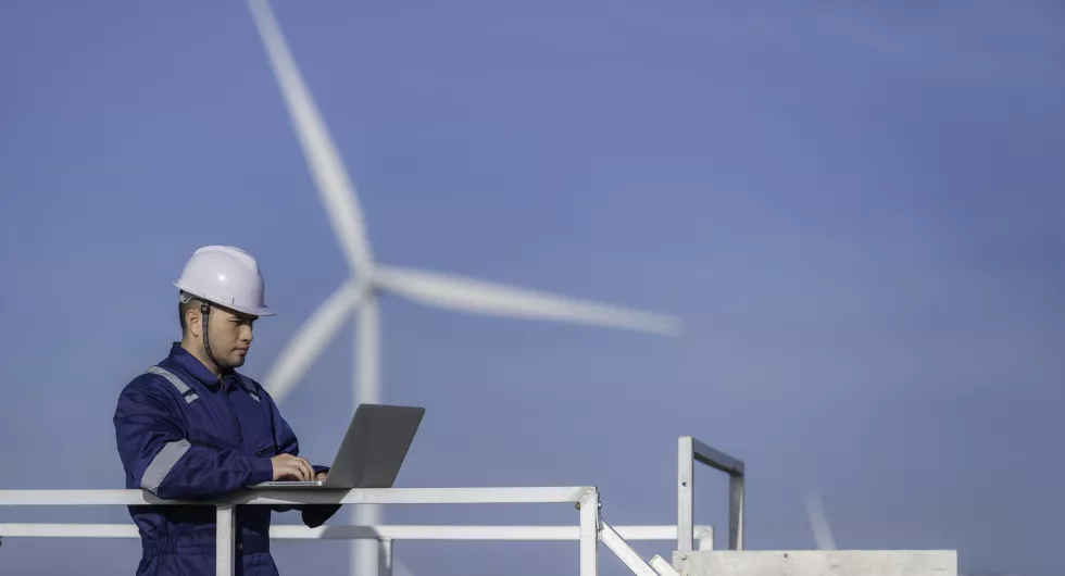 two-engineers-working-holding-report-wind-turbine-farm-power-generator-station-mountainthailand-peopletechnician-man-woman-discuss-about-work