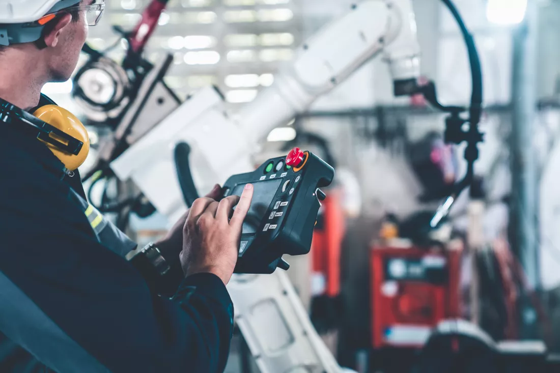young-factory-worker-working-with-adept-robotic-arm