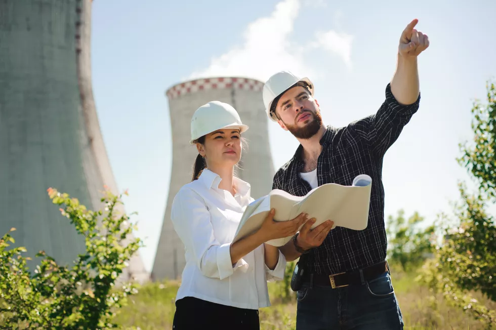 two-engineers-standing-electricity-station-discussing-plan