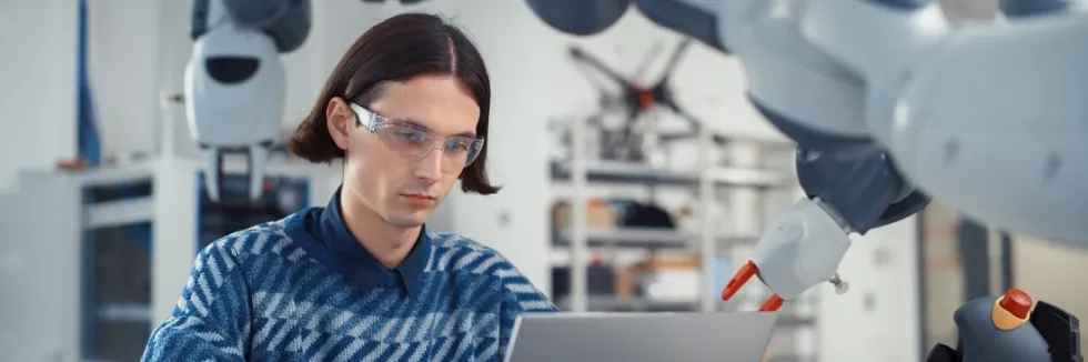 Inzynieria-autonomicznych-systemow-cyfrowych-test-student-programuje-ramie-robota-na-laptopie