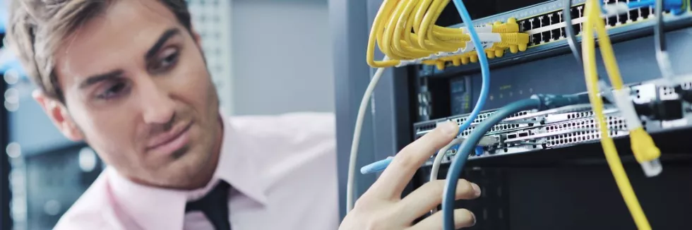 Inzynieria-sieci-i-cyberbezpieczenstwo-test-mlody-inzynier-podlacza-kable-sieciowe-w-szafie-rack