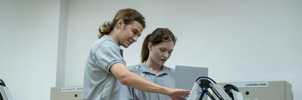 student-i-studentka-programuja-male-ramie-robota
