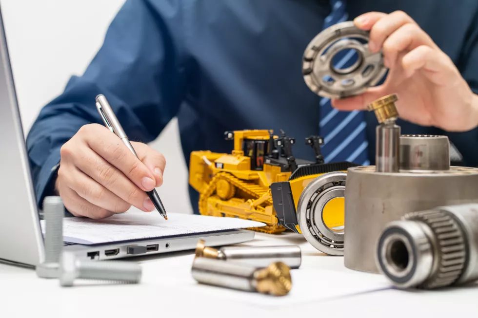 professional-mechanic-engineer-inspecting-valve-plate-hydraulic-piston-pump-writing-reports-working-day-office-repair-maintenance-heavy-machinery-concept