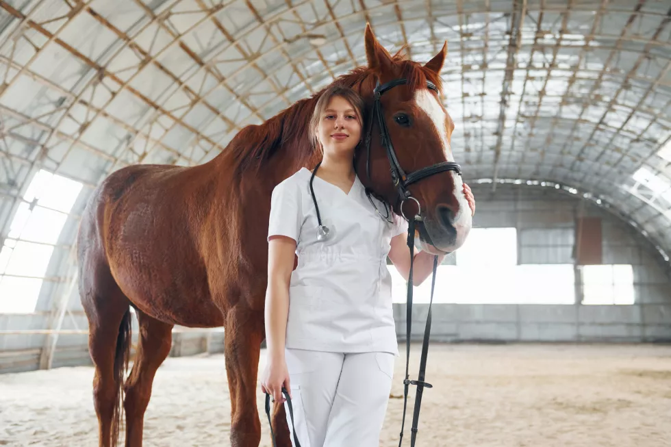 smiling-posing-camera-standing-together-female-doctor-white-coat-is-with-horse-stable