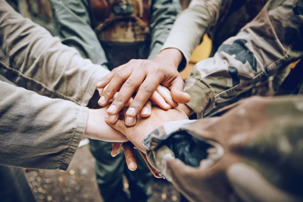 military-team-work-hands-huddle-mission-strategy-motivation-paintball-battlefield-goals-collaboration-army-people-with-support-partnership-group-ready-soldiers