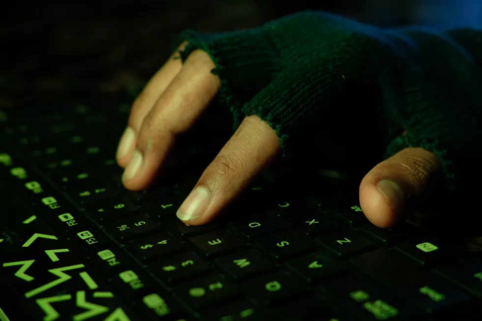 hacker-hand-stealing-data-from-laptop-top-down