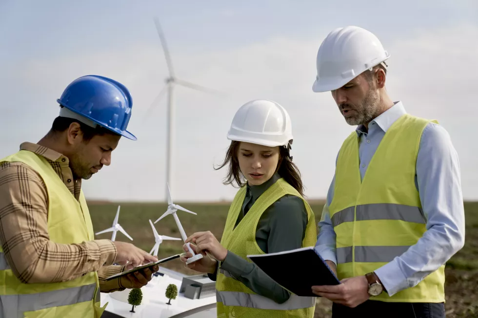 team-caucasian-latin-engineers-standing-wind-turbine-field-discussing(1)