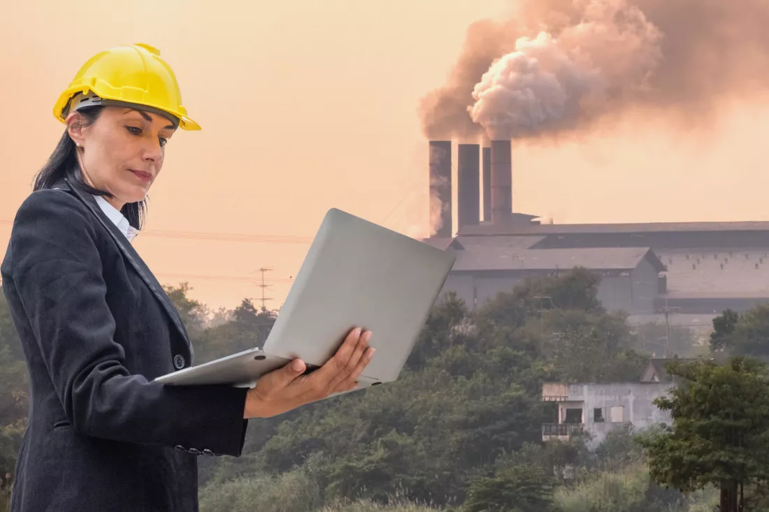 leader-woman-engineer-holding-laptop-checking-burning-smoke-chimney-factory-background