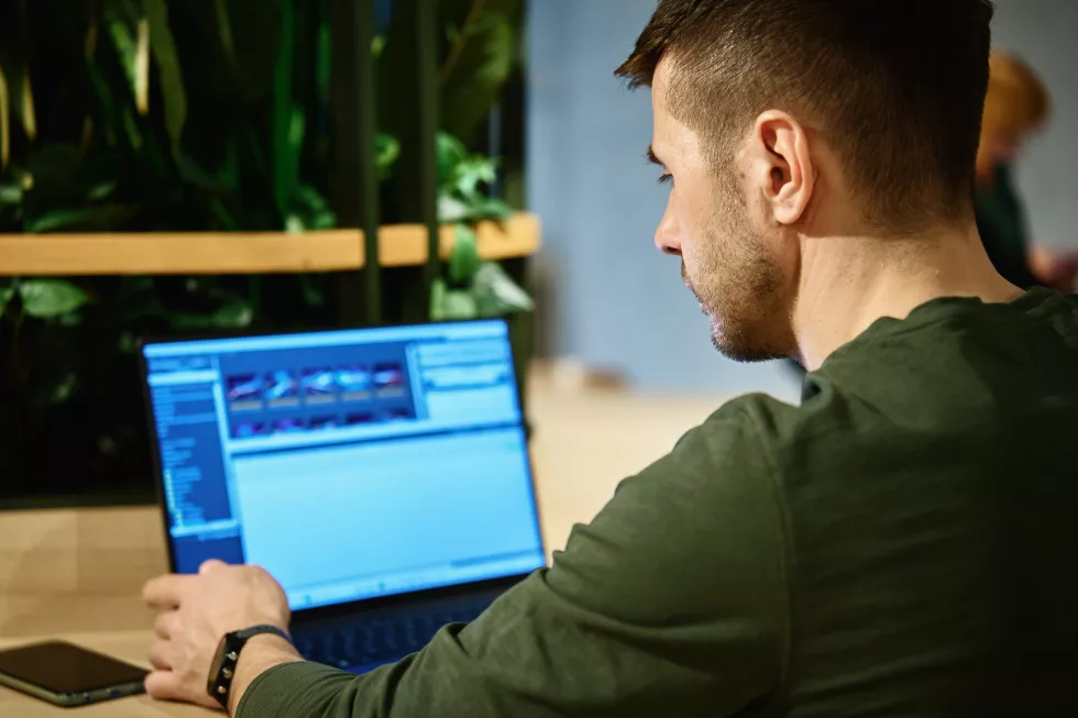male-hand-typing-laptop-keyboard-cafe