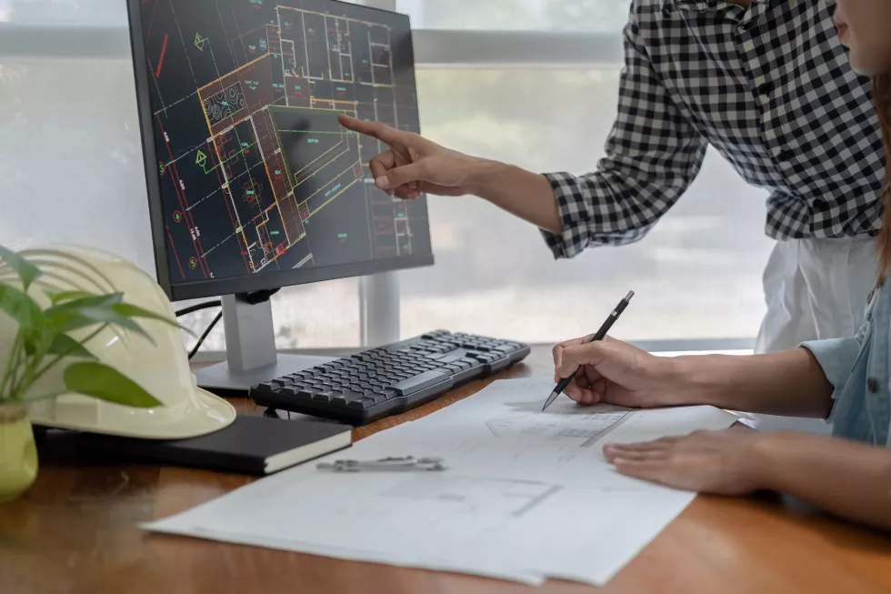 engineers-discuss-blueprint-while-checking-information-tablet-computer-office