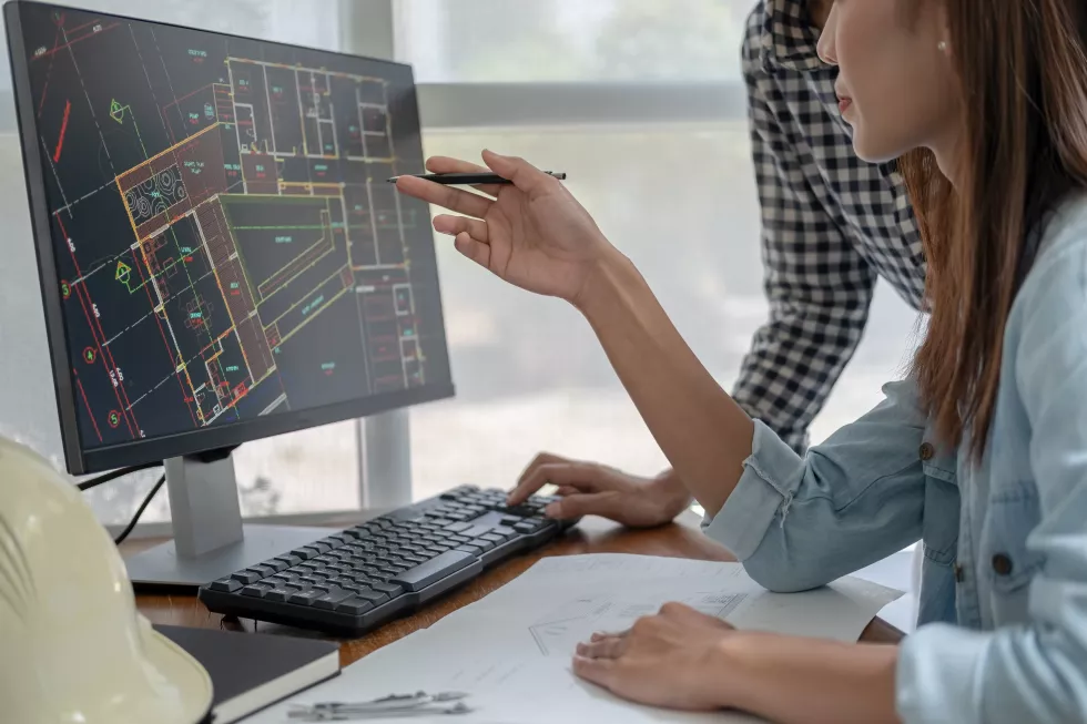 engineers-discuss-blueprint-while-checking-information-tablet-computer-office