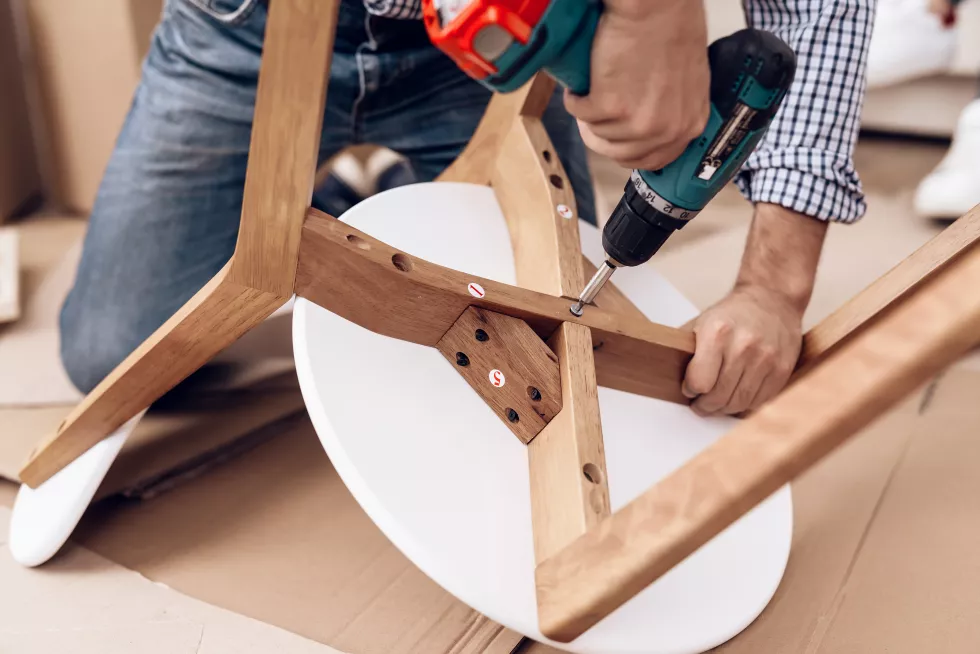 furniture-assembler-with-drill-hands-repairs-chair